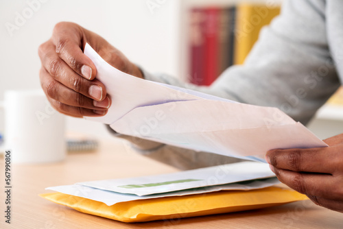 man hands putting a letter inside an envelope