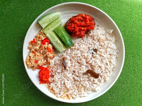 white rice and cucumber in a round plate from above view photo