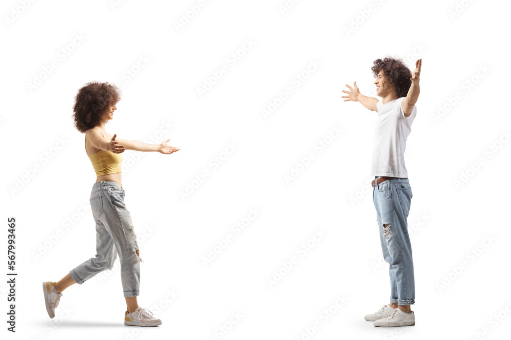 Full length profile shot of a young woman walking to hug a young casual man Full length profile shot of a young woman walking to hug a young casual man