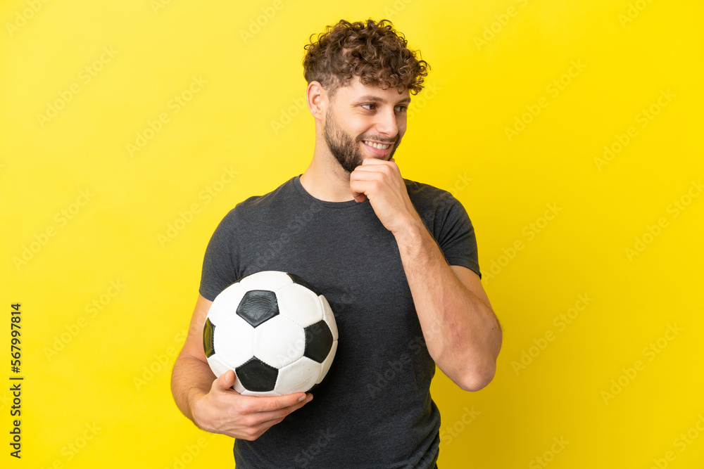 Handsome young football player man isolated on yellow background looking to the side and smiling Handsome young football player man isolated on yellow background looking to the side and smiling