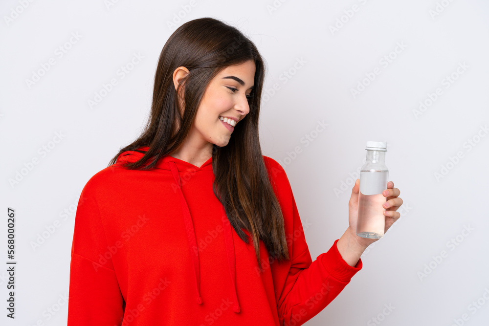 Young Brazilian woman with a bottle of water isolated on white background with happy expression Young Brazilian woman with a bottle of water isolated on white background with happy expression