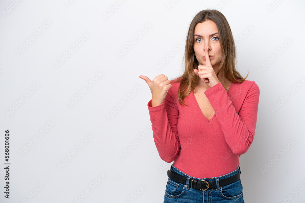 Young caucasian woman isolated on white background pointing to the side and doing silence gesture Young caucasian woman isolated on white background pointing to the side and doing silence gesture
