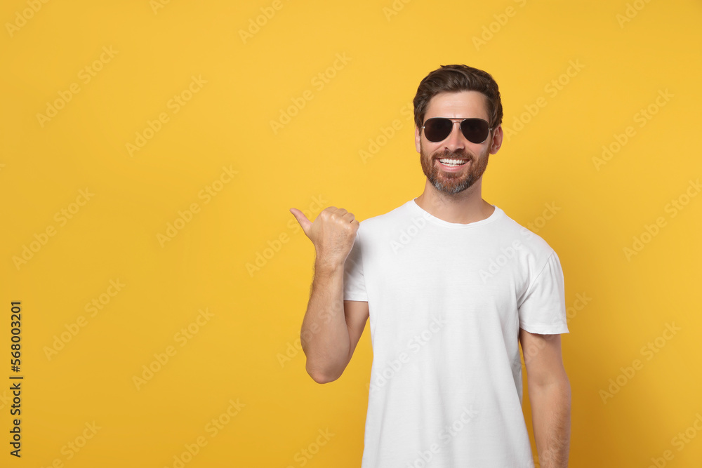 Portrait of smiling bearded man with stylish sunglasses on orange background. Space for text Portrait of smiling bearded man with stylish sunglasses on orange background. Space for text