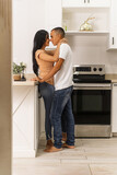 couple hugging at home in the kitchen.
