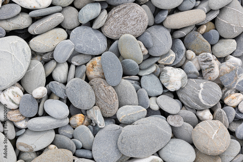 Stones on a shingle beach rounded and polished by coastal sea erosion, flat lay. New Zealand Stones on a shingle beach rounded and polished by coastal sea erosion, flat lay. New Zealand