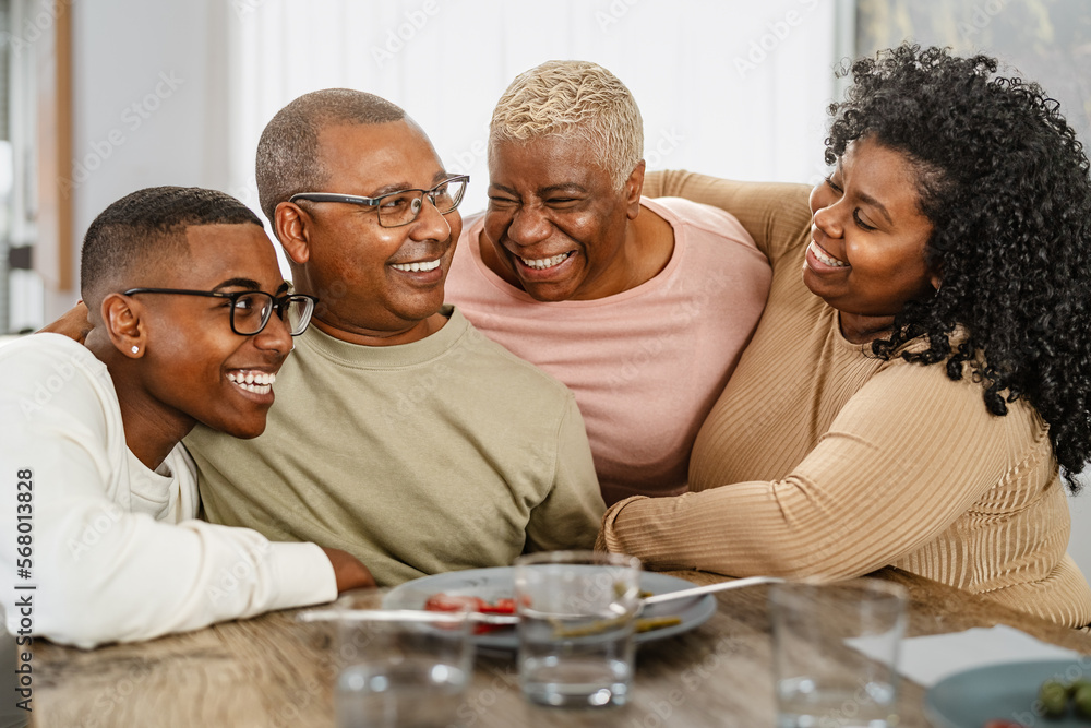 Happy African family enjoying lunch together at home - Parents unity concept Happy African family enjoying lunch together at home - Parents unity concept