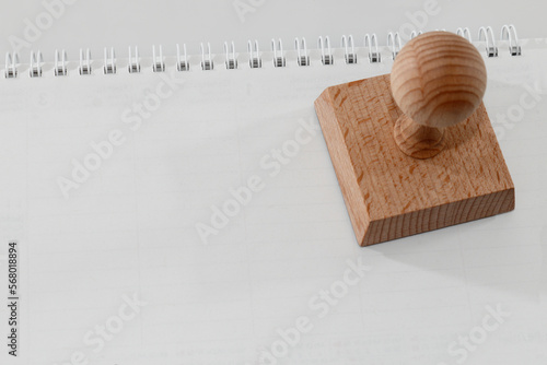 Stempel quadratisch aus Holz am leeren Kalender