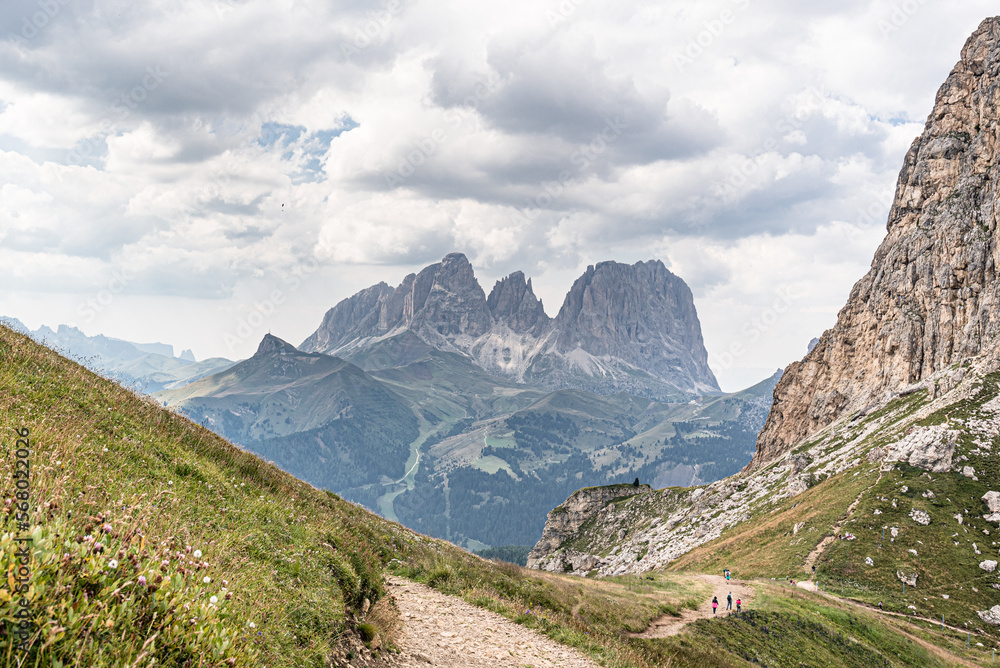 View of Sassolungo and Sassopiatto mountain massifs as seen from trail #601 (Alta Via 2 trail) descending to Pordoi Pass from Baita Fedarola refuge, Dolomites, South Tyrol, Italy 