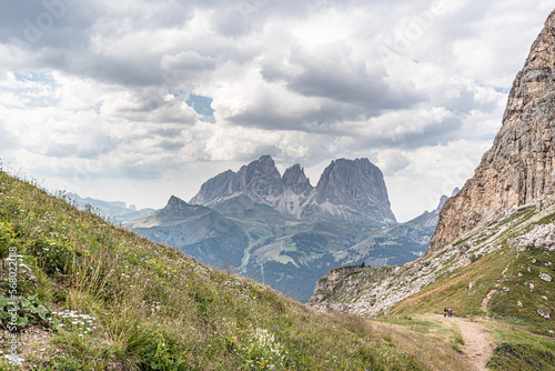 View of Sassolungo and Sassopiatto mountain massifs as seen from trail #601 (Alta Via 2 trail) descending to Pordoi Pass from Baita Fedarola refuge, Dolomites, South Tyrol, Italy photo