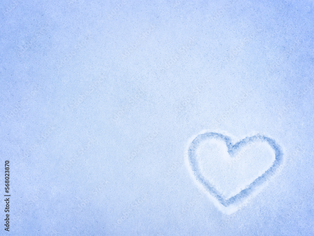 A heart drawn on the snow. Winter, snowy, natural background. View from above. Copy space