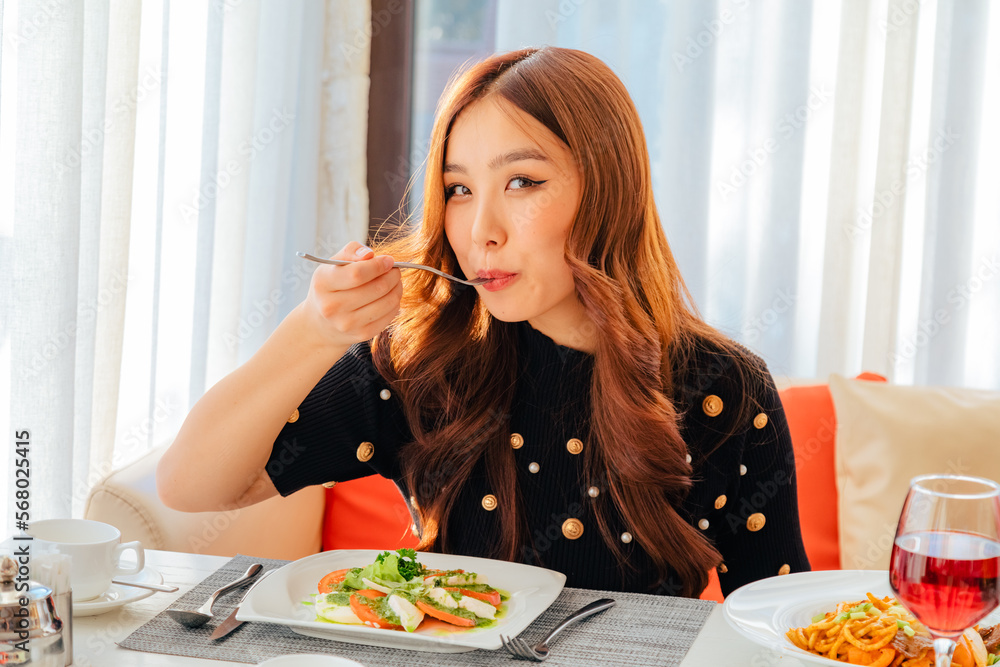 Closeup of asian woman eating fresh vegetable salad Closeup of asian woman eating fresh vegetable salad