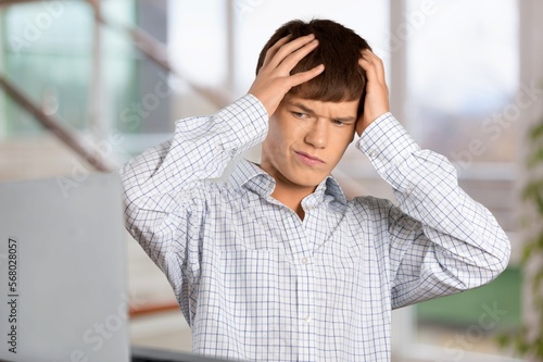 Overworked young man while working or studing from home © BillionPhotos.com