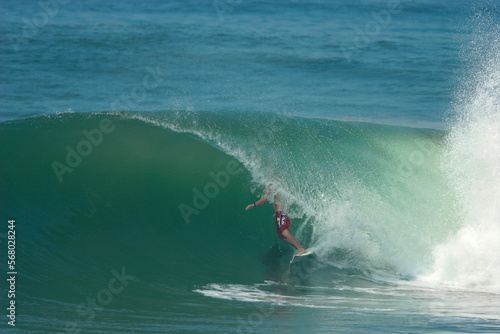 A surfer rides a perfect tube on a wave in the ocean. photo