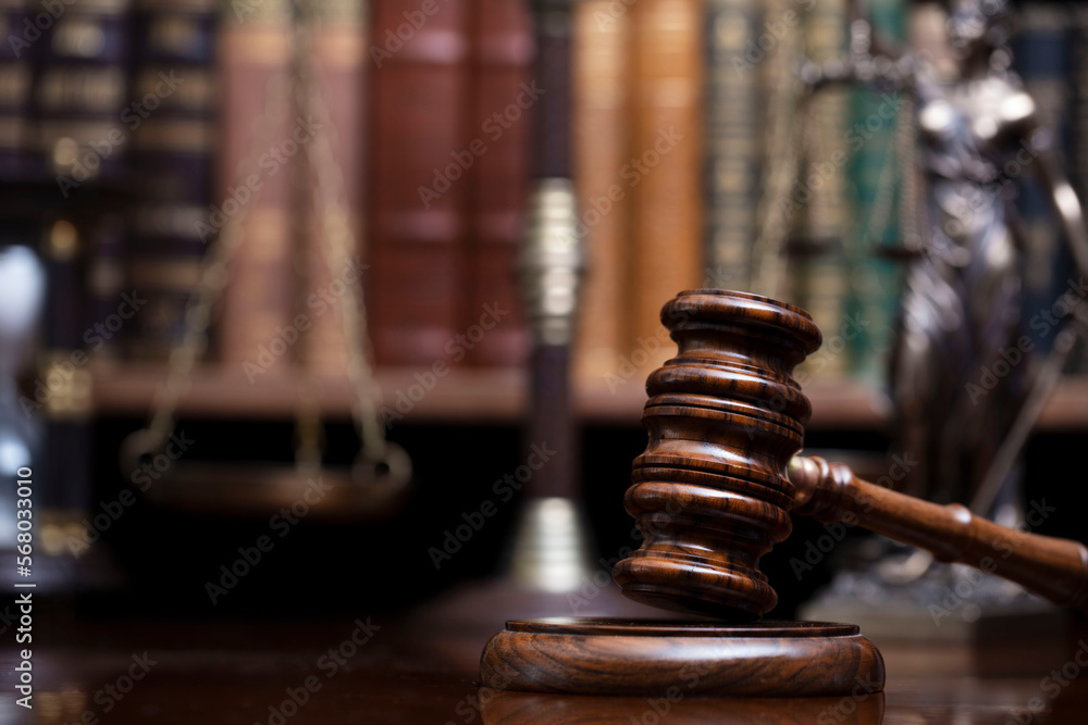Lawyer office. Judge’s gavel, Themis sculpture and legal books in the bookshelf. Lawyer office. Judge’s gavel, Themis sculpture and legal books in the bookshelf.