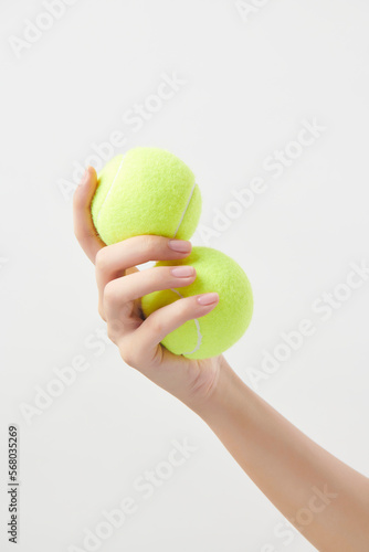 두개의 테니스 공을 들고 있는 여성의 손 © BRS images