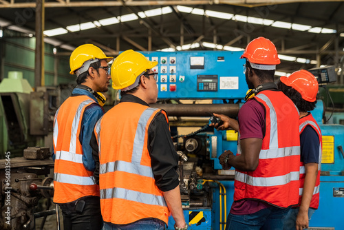 Metal worker teaching trainee on machine. Engineer men wearing uniform safety in factory.