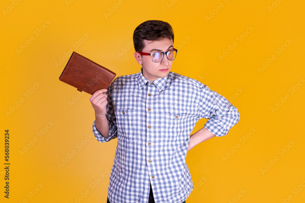 A handsome guy with a book on a yellow background A handsome guy with a book on a yellow background