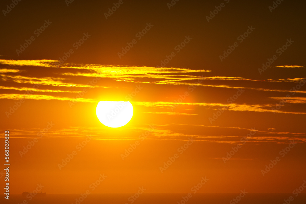 A view of a beautiful orange sunrise over the ocean.