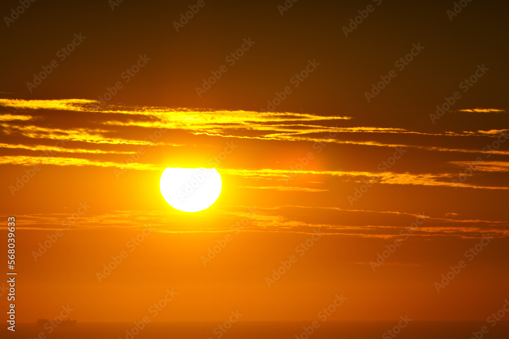 A view of a beautiful orange sunrise over the ocean. A view of a beautiful orange sunrise over the ocean.