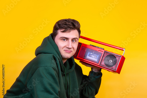 A handsome guy with a boombox on a yellow background