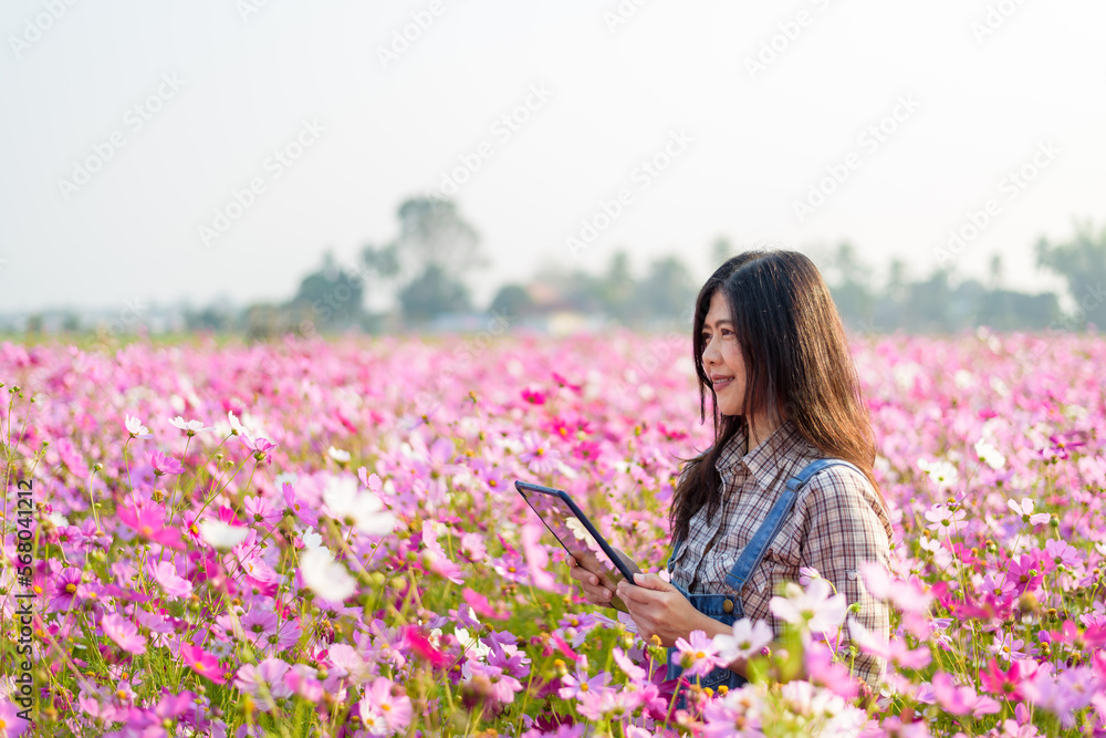 Happy woman farmer owner holding tablet at flower farm for modern farming, technology,smart woman, flower business idea concept. Happy woman farmer owner holding tablet at flower farm for modern farming, technology,smart woman, flower business idea concept.