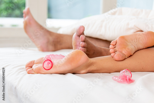 Couple just finished make love by using condom for protecting pregnant or birth control. Conscious sexual life  using condom for protection. Using contraception condom while having sex in bed.