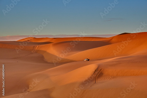 sand dunes and car driving in the desert