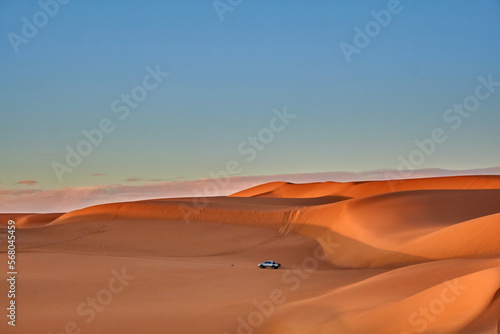View of Sands dunes and car driving in the desert of Algeria 