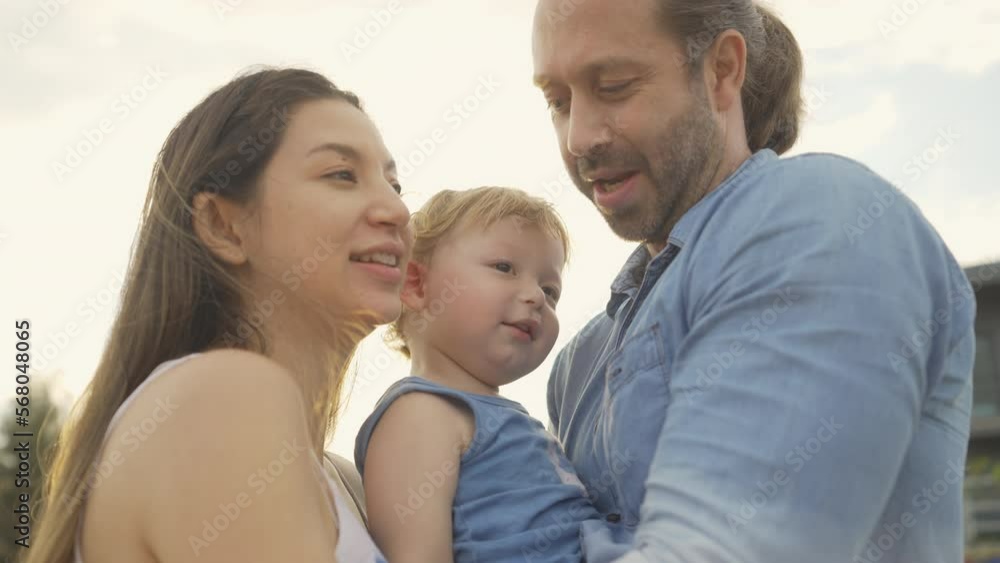 Caucasian family couple and baby enjoy and fun outdoor lifestyle travel at the sea on summer holiday vacation. Father, mother and little child kid walking and playing together on the beach at sunset. Caucasian family couple and baby enjoy and fun outdoor lifestyle travel at the sea on summer holiday vacation. Father, mother and little child kid walking and playing together on the beach at sunset.