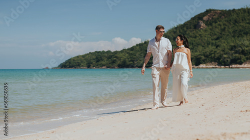 Romantic couple love happy and walking on the beach. Young man and woman smiling and enjoying together on summer vacation. honeymoon lifestyle, Happy aniversary.