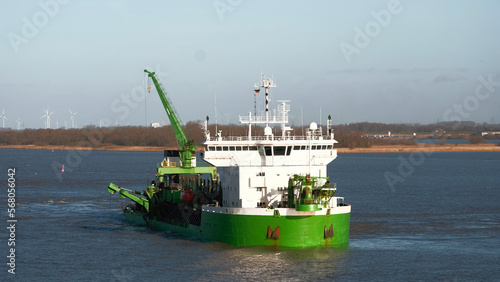 Elbe river, Germany - 01 20 2023: Belgian trailing suction hopper dredger with forward wheelhouse restricted in ability to maneuver during river maintenance photo