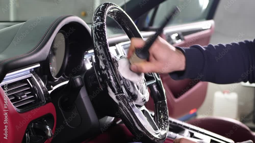 Worker wipes the steering wheel of the car, dry cleaning and interior washing. Detailing studio Worker wipes the steering wheel of the car, dry cleaning and interior washing. Detailing studio