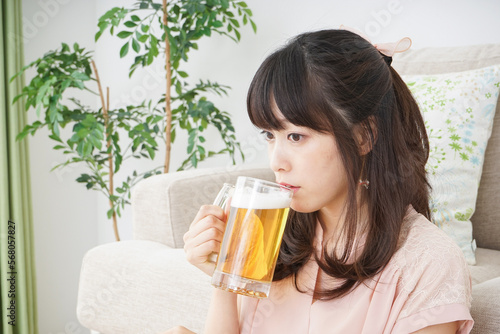 自宅でビールを飲む若い女性