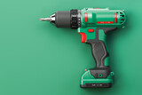 Green electric screwdriver drill on green background with space for text.