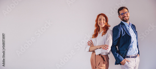 Photo Business partners posing in front of gray background, looking at camera and smiling