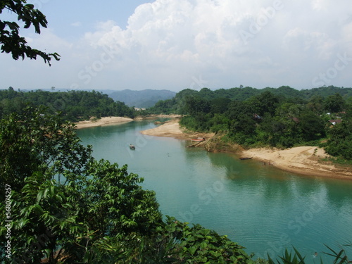 The boat, the green water river, and the hills of Lalakhal, a popular tourist destination in Sylhet Bangladesh.