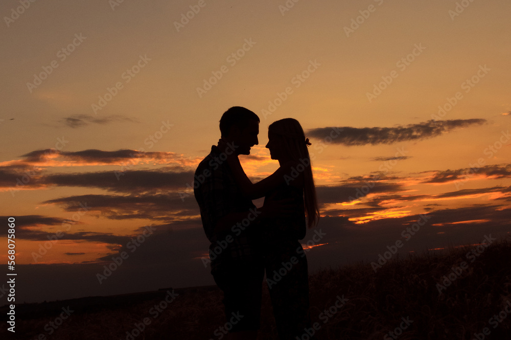 couple in love blonde girl in silhouette against an sunset