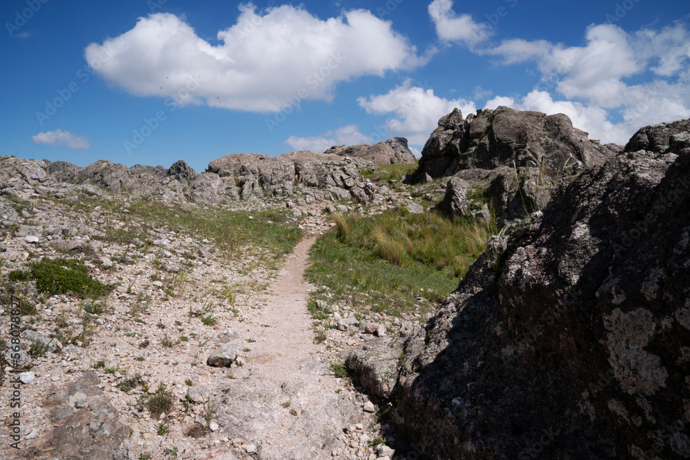View of the hiking path across the rocky hills in a sunny day. 