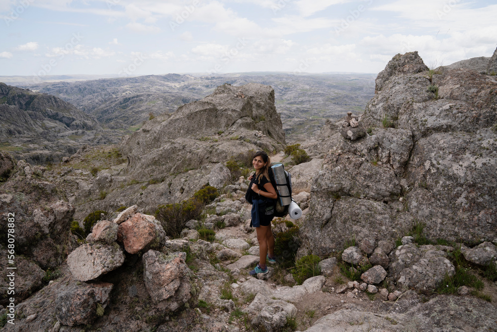 View of a female hiker high in the rock massif The Giants in Cordoba, Argentina.