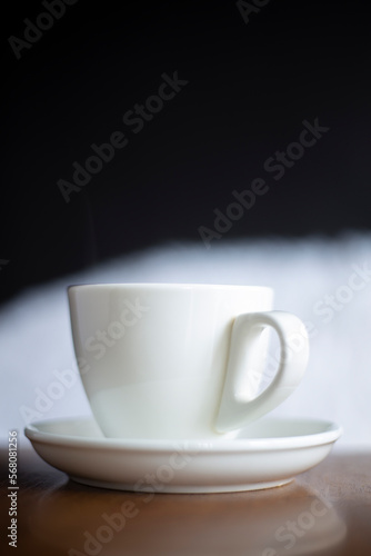 White cup hot drinking with steam on pine wooden table 