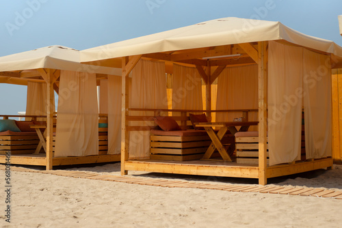 Wooden tents on the sandy beach. Cafe. Restaurant. Shady place for food on the coast. Shelter.