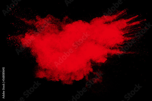 Red powder explosion cloud on black background. Freeze motion of red color dust particle splashing.