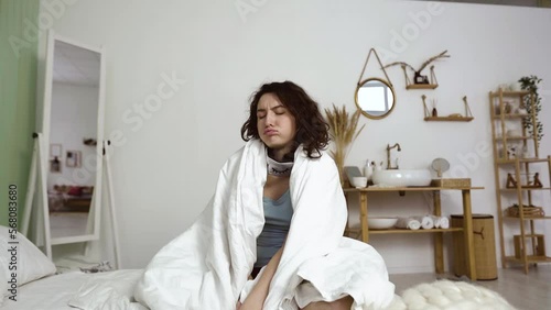 Tired, exhausted young woman wrapped in a blanket falls on the bed face down