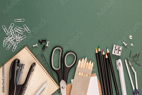 stationery items around of image on green background. Back to school background, banner with copy space. Student's or engineer's supplies. Office objects on dark green background. Calculator, keyboard