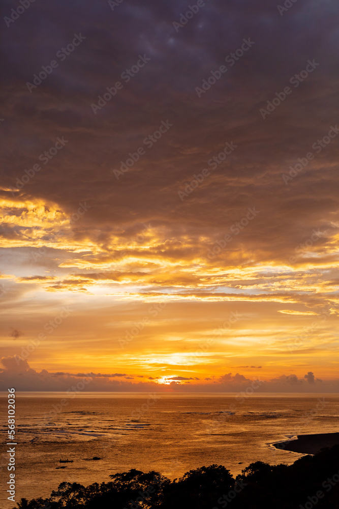 Fototapeta premium Orange and purple sunset reflection on ocean