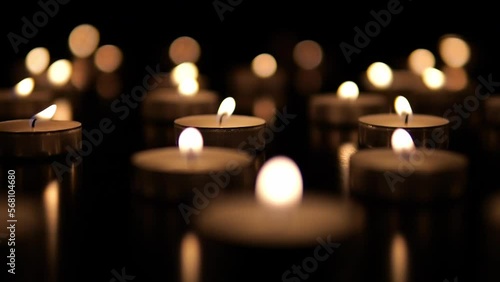 Many candles burn in the dark. Memorial day with candles. Lighted memorial candles. Funeral candles close-up. photo