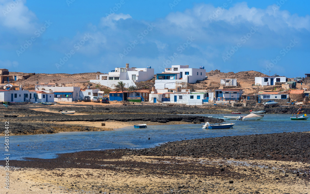 Vista panorámica del pueblo Majanicho lleno de casas blancas y barcos de pesca en la turística Fuerteventura desde la playa El Hierro o Playa de las Palomitas en la costa de las Islas Canarias