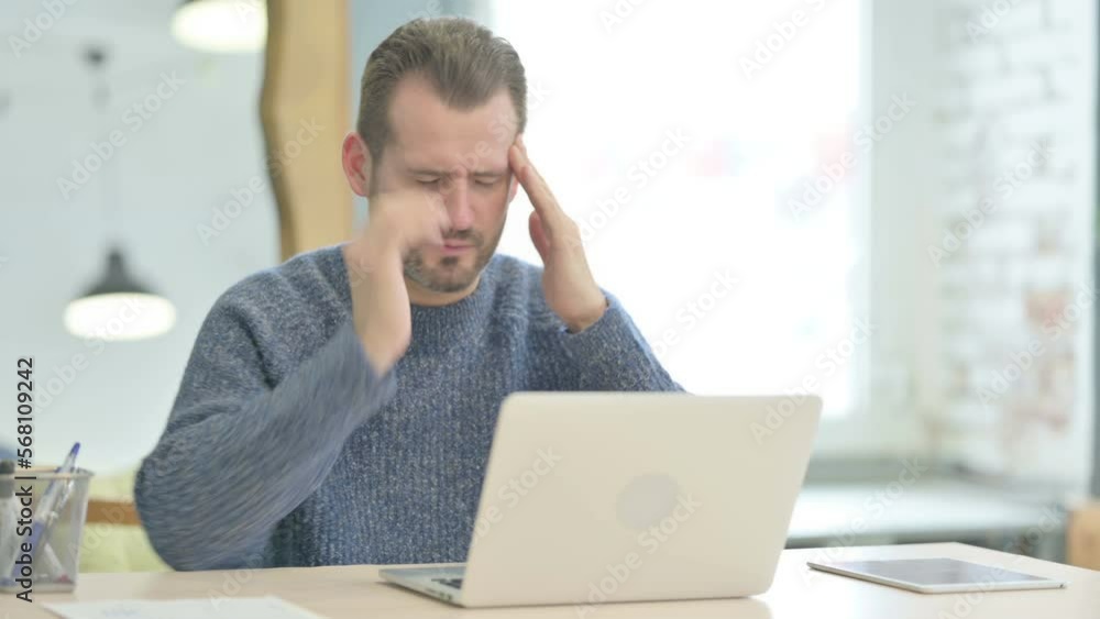 Middle Aged Man having Headache while Working on Laptop