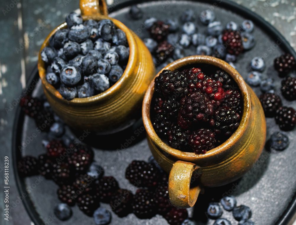 Guatemalan artisan jars filled with red fruits, blueberries and blackberries Guatemalan artisan jars filled with red fruits, blueberries and blackberries