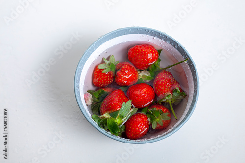 red strawberry with water in bowl